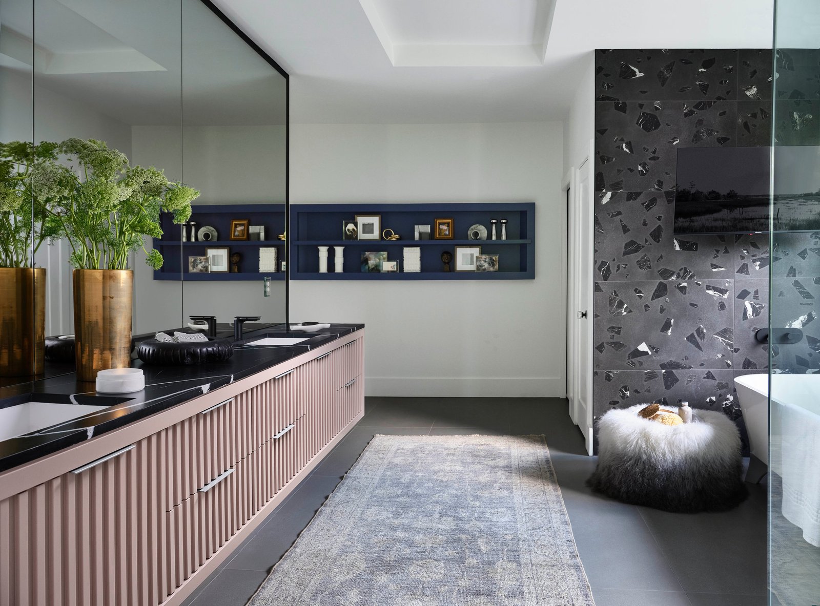 Primary bathroom of The Dogwood Residence: blush fluted vanity, black stone, terrazzo shower.